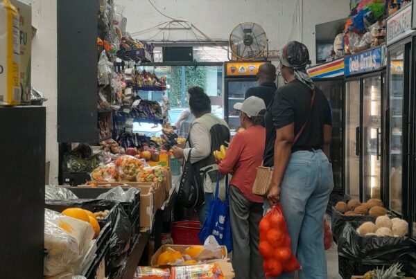 Image of customers waiting in line to pay for their produce at a community supermarket/bodega near union station.