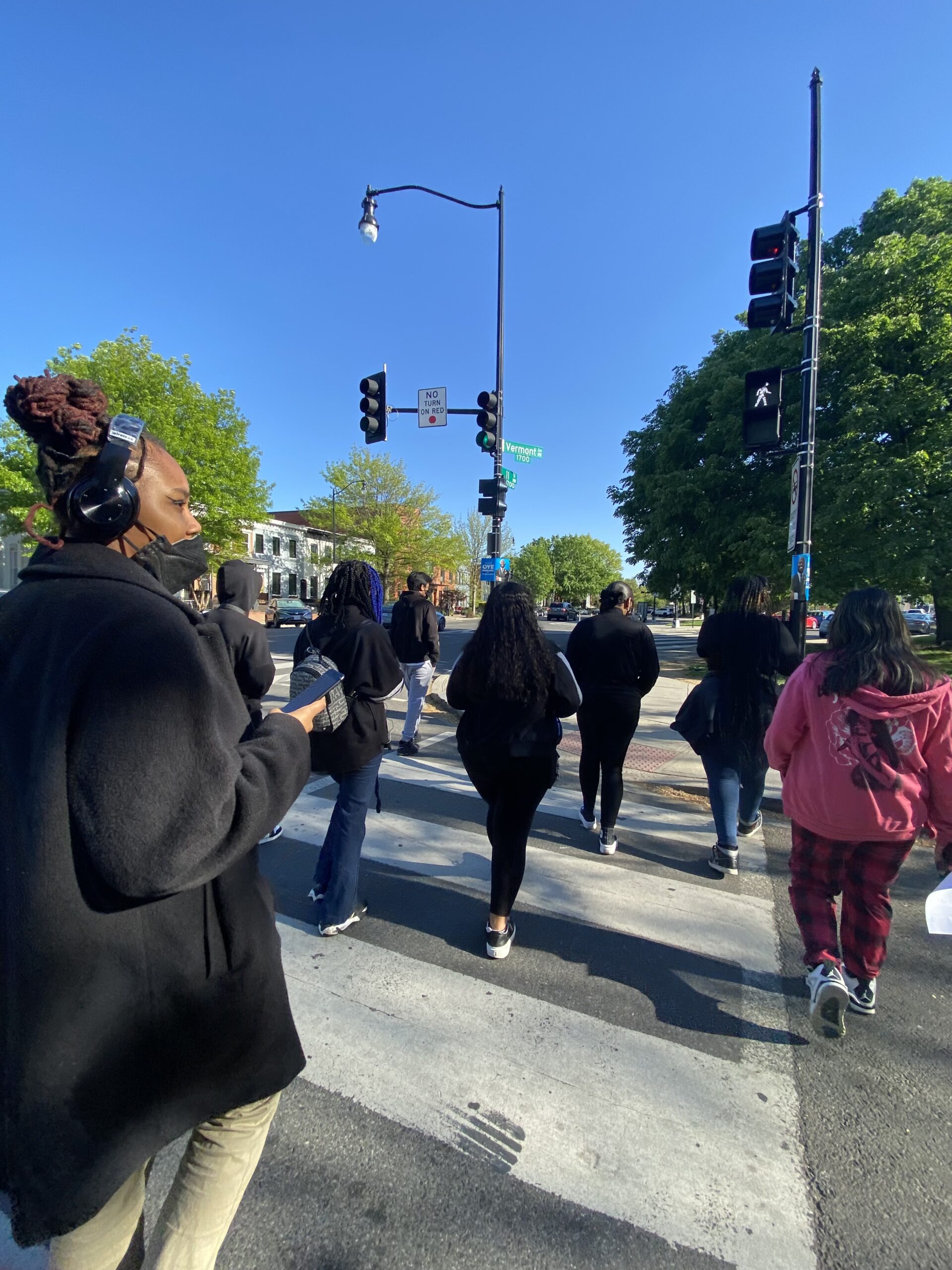 Image of youth gathering together walking the streets of DC, building community as part of the Youth Organizing Collective program.